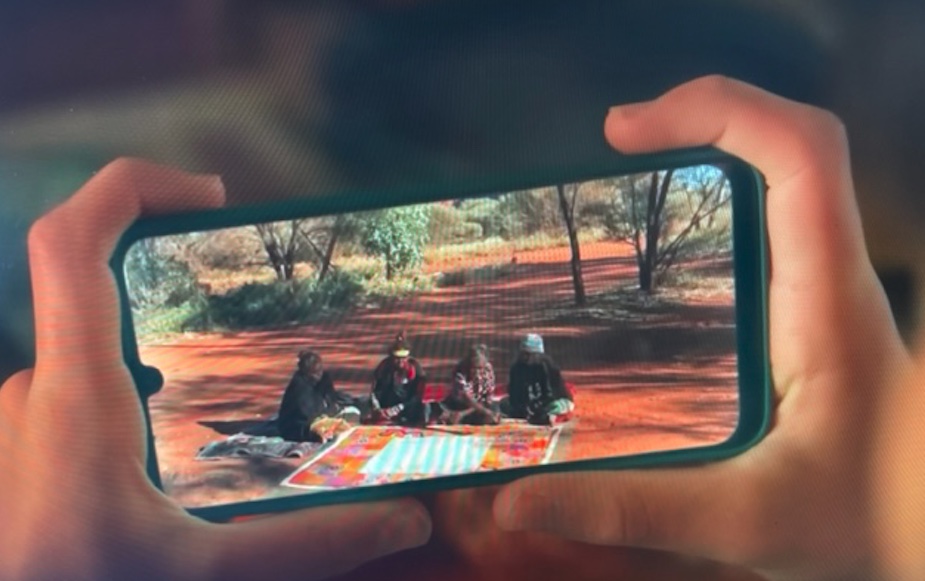 Detail from the You're the Voice Referendum ad, showing the Uluru Statement being viewed on a mobile phone